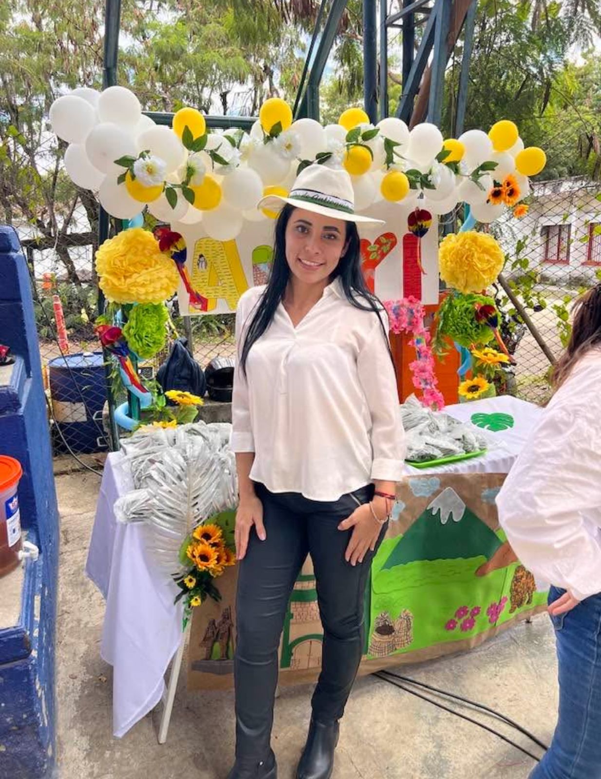 Eglis at festival booth wearing white sombrero